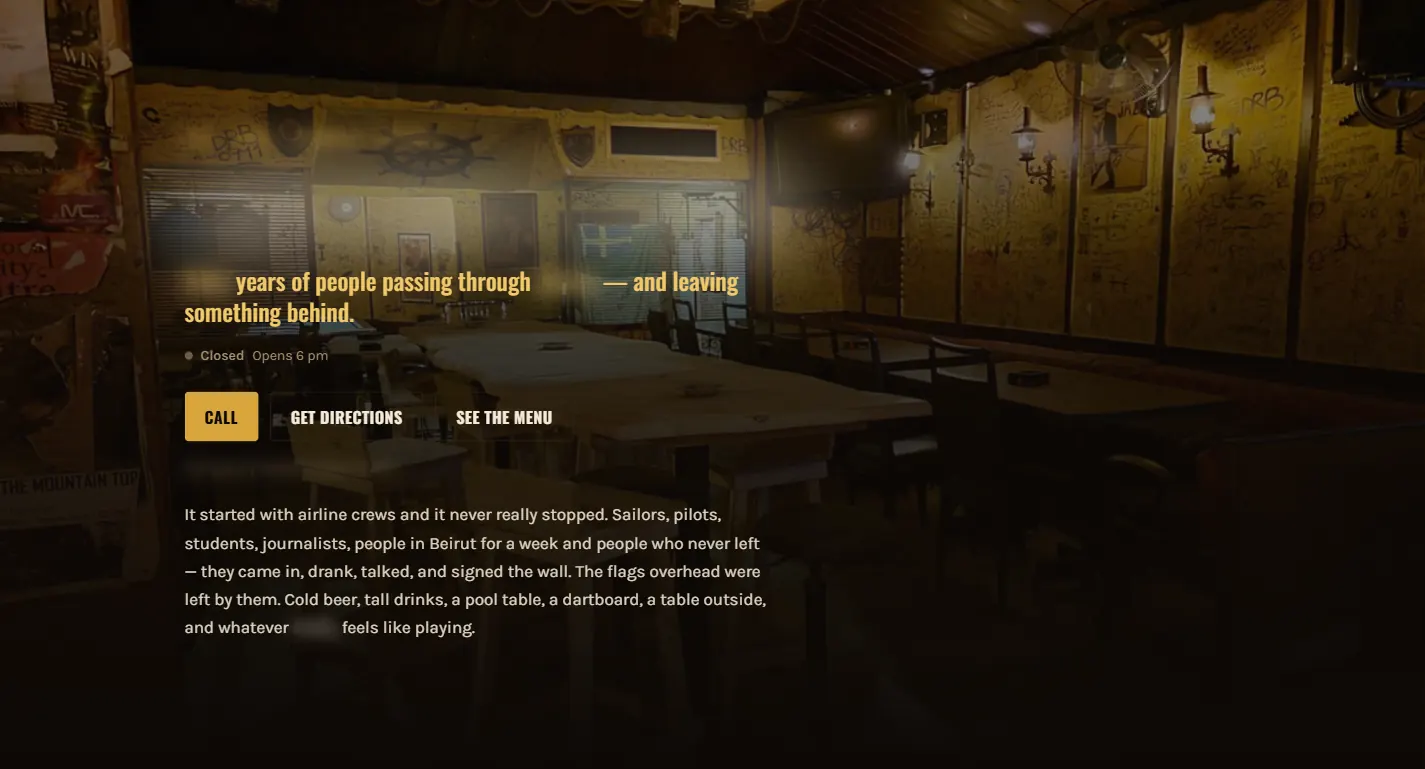 Bar website hero over a warmly lit photograph of the room — wood panelling covered in signatures, wall lanterns and a ship's wheel. A gold subheading about people passing through and leaving something behind sits above an opening-hours line, Call, Get Directions and See the Menu buttons, and a paragraph about the airline crews, sailors and journalists who signed the wall. The bar's name and location are blurred out.